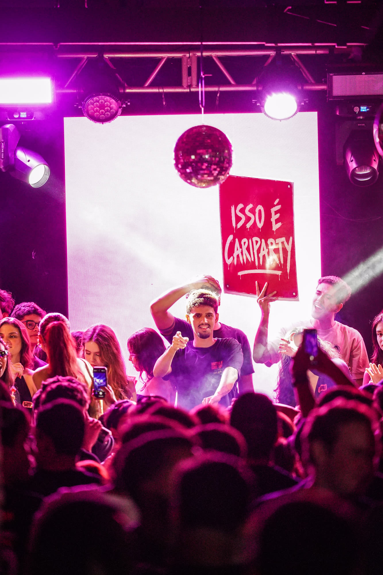 Plateia com placa 'ISSO É CARIPARTY'